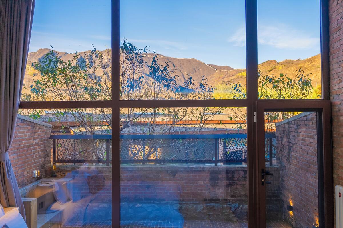A room with a large window overlooking a mountainous landscape.