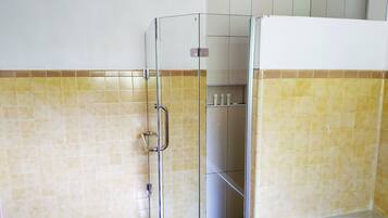 A bathroom with a shower enclosure, tiled walls, and a bathtub.