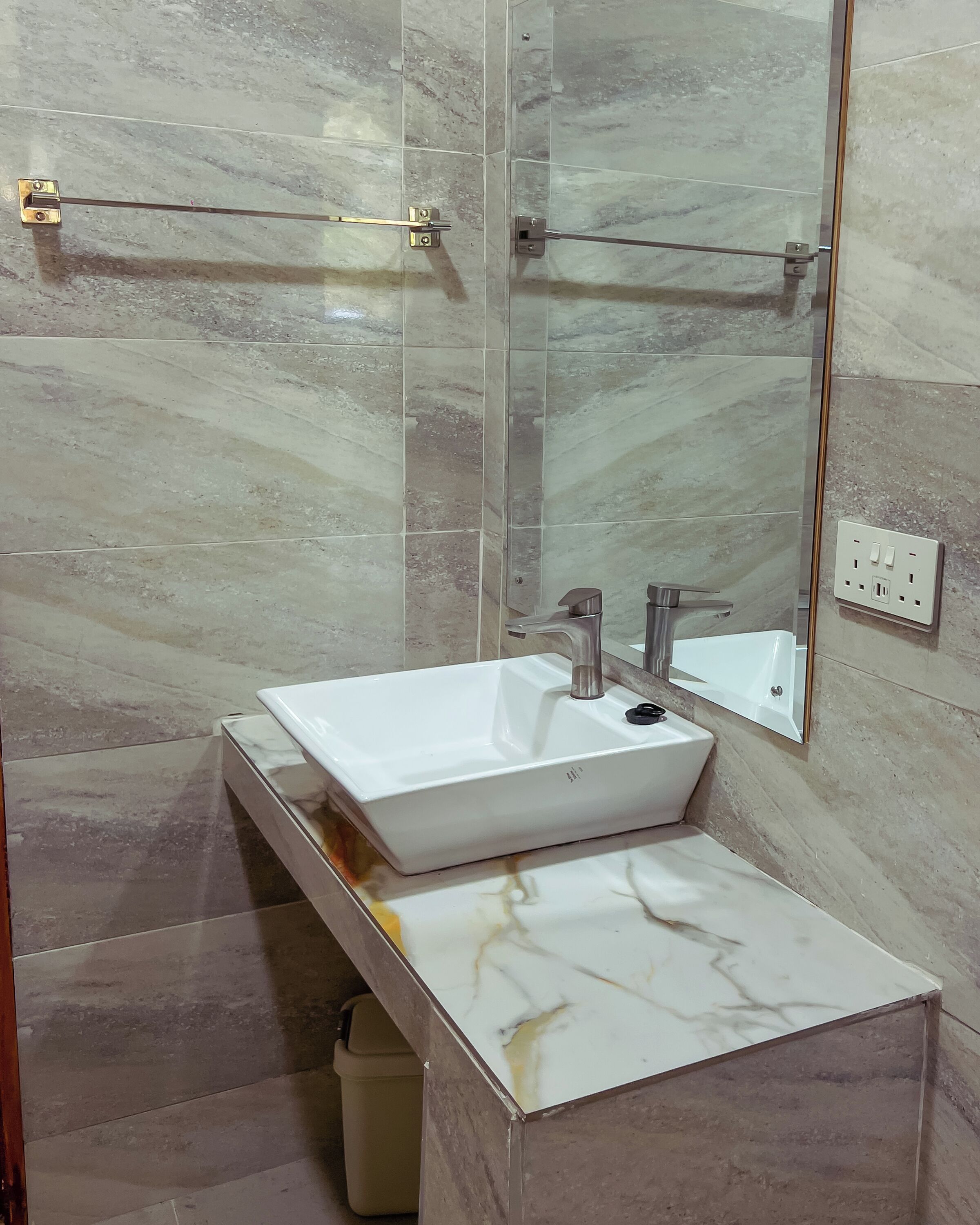 A bathroom with a white sink, a mirror, and a shower area.