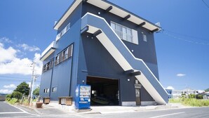 A modern building with a unique angular design, a garage entrance, and a vending machine on the sidewalk.
