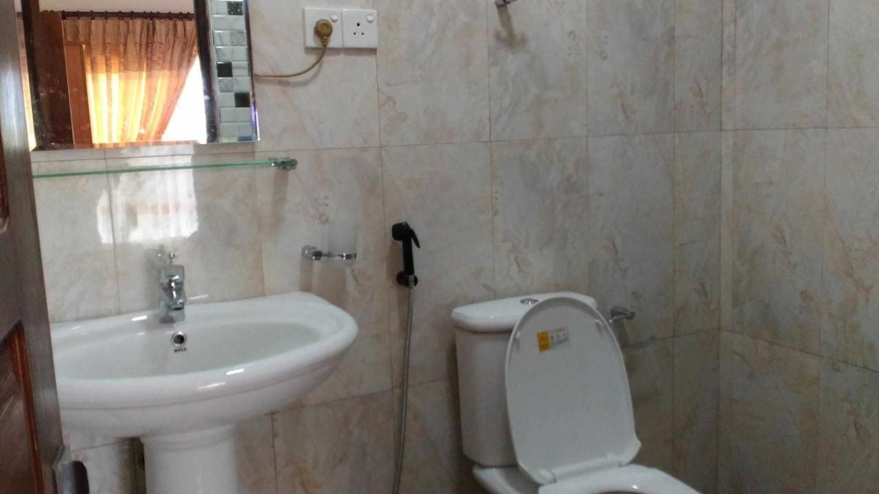 A bathroom with a white sink, a toilet, and a glass shower enclosure.