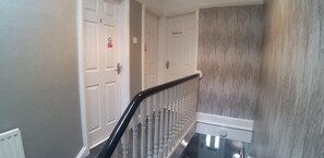 A staircase with white doors, some marked 'PRIVATE,' and a wall with a tree pattern. - Alexandra Park Guest House (Belfast)