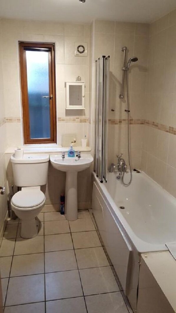 A bathroom with a toilet, sink, and bathtub. - Alexandra Park Guest House (Belfast)