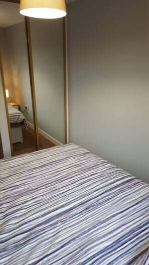 A room with a bed, a mirror, and a lamp. - Alexandra Park Guest House (Belfast)