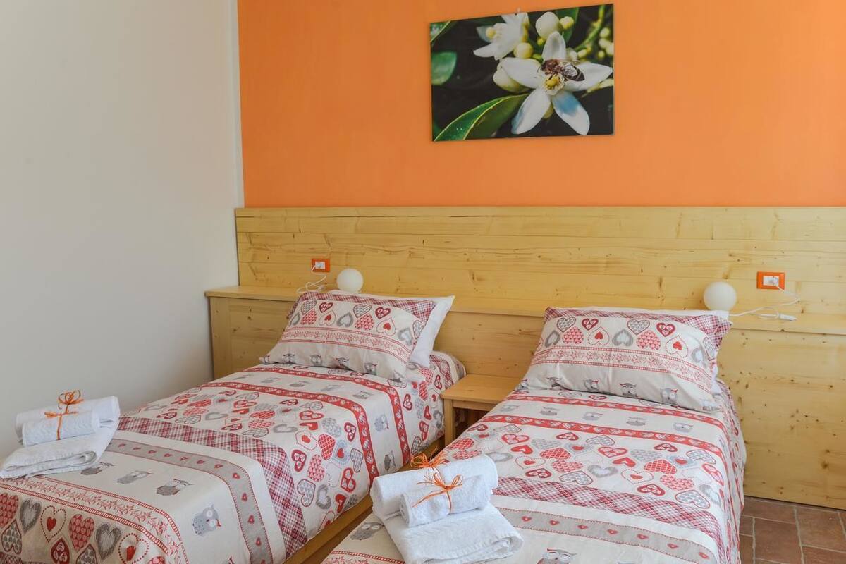Habitación doble con dos camas, cada una con ropa de cama estampada en rojo y blanco.