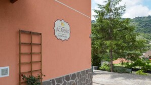 Un edifici amb un cartell que diu "Al Cuadrado Bed & Breakfast" i una paret de pedra.