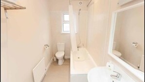 A bathroom with a bathtub, toilet, and sink. - Crumlin Road Guesthouse (Belfast)