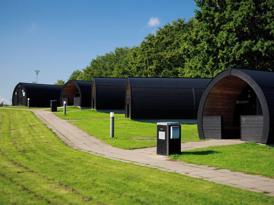 A row of cylindrical buildings with a pathway leading to them.