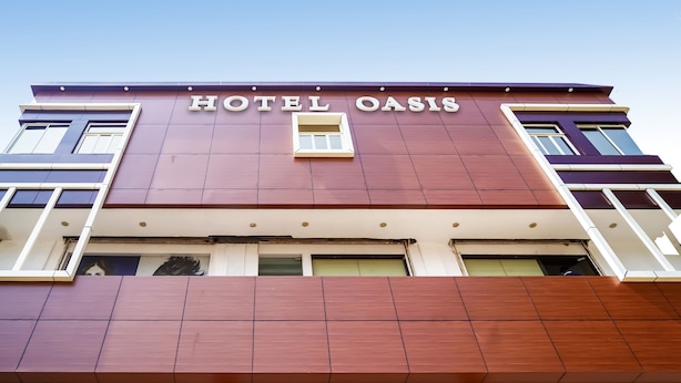 A hotel named "HOTEL OASIS" with a modern facade, large windows, and a prominent entrance. - Treebo Oasis, Laxmisagar (Bhubaneshwar)