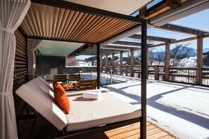 A sunlit room with a wooden deck, a glass wall, and a view of a snowy landscape. - Waldhotel by Bürgenstock Lake Lucerne (Ennetbuergen)