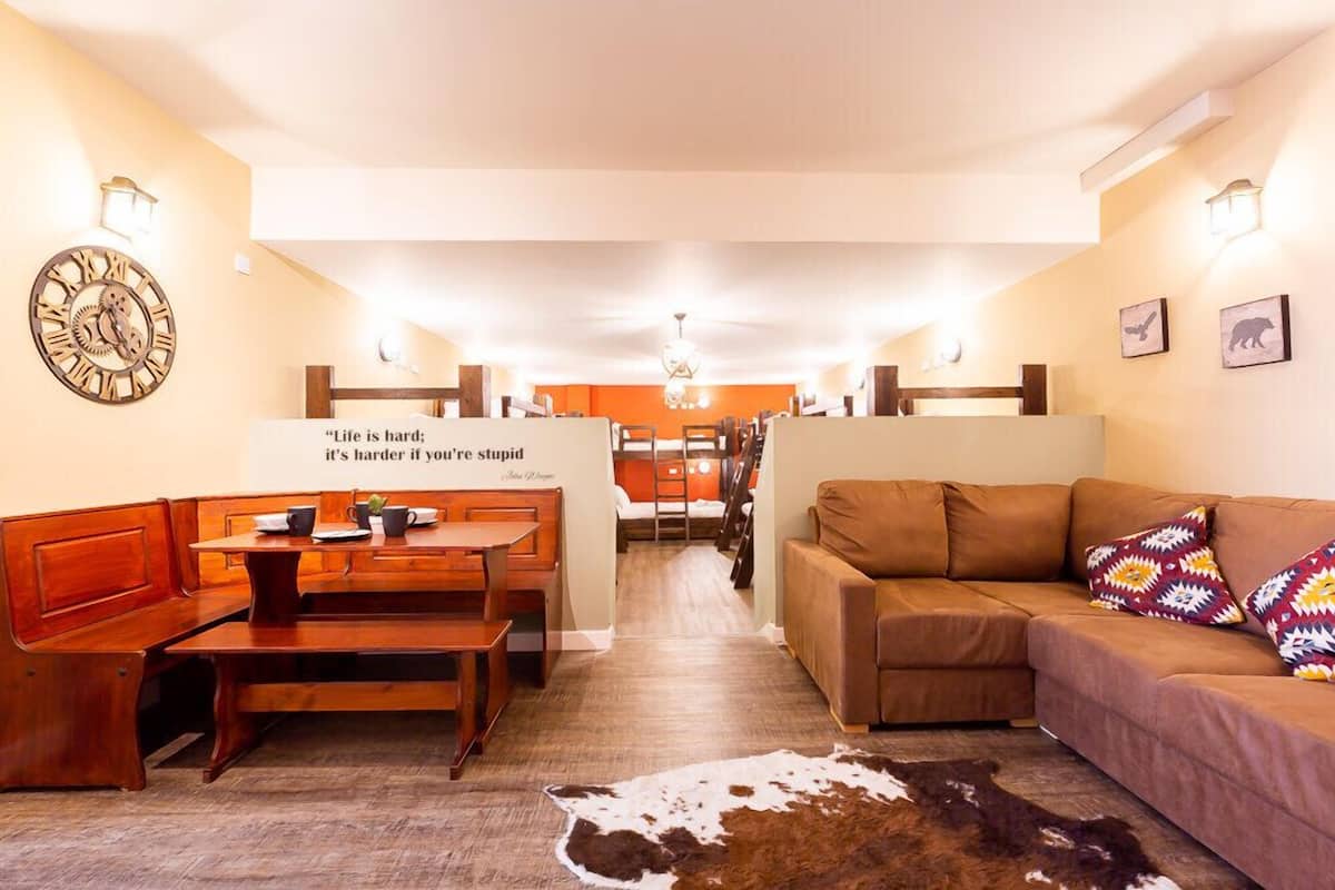 A cozy interior with a wooden bench, a sofa, and a dining area with a table and chairs.