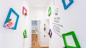 A hallway with colorful picture frames and a motivational quote on the wall. - Honeypot House (Newcastle-upon-Tyne)