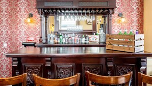 A bar area with a wooden counter, hanging glasses, and bottles of beverages. - Honeypot House (Newcastle-upon-Tyne)