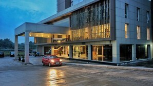 A modern building with a covered entrance and a glass facade. - CoreHotel Malioboro City Yogyakarta (Depok)