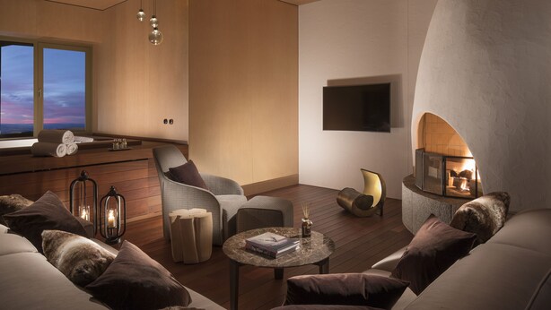 A modern living room with a fireplace, comfortable seating, and a view of the sky through a large window. - Bürgenstock Hotels & Resort – Palace Hotel (Ennetbuergen)