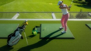 A golf course with a player on a tee box, a golf bag, and a putting green. - Bürgenstock Hotels & Resort – Palace Hotel (Ennetbuergen)