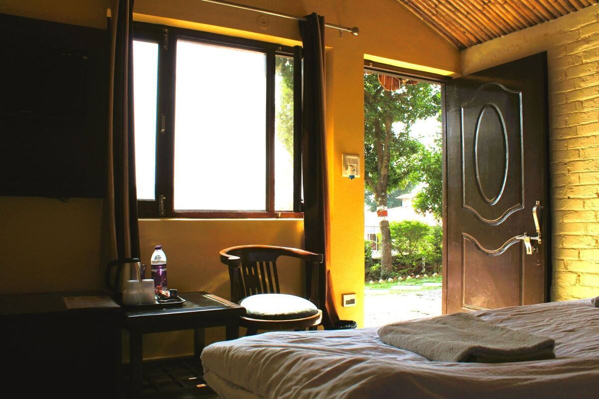 Una habitación con cama, una silla, un escritorio y ventana.