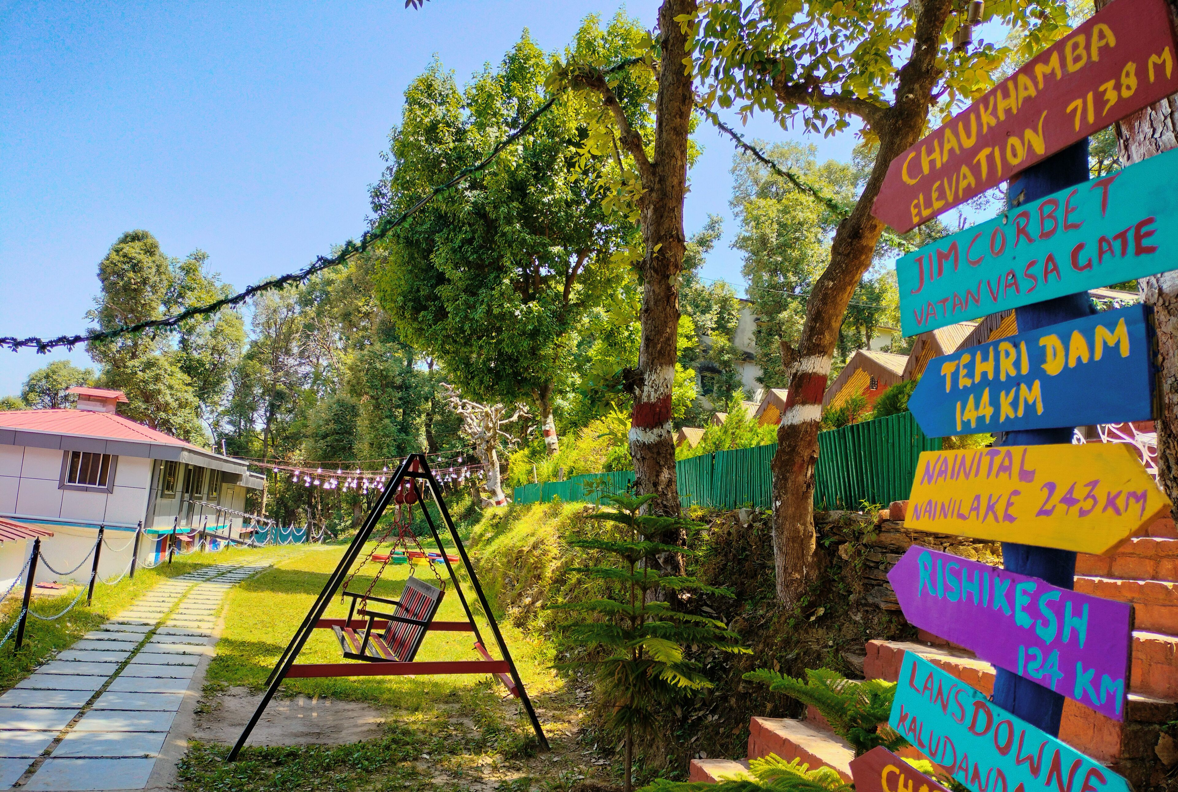 A playground with a swing set and a signpost with directional signs.