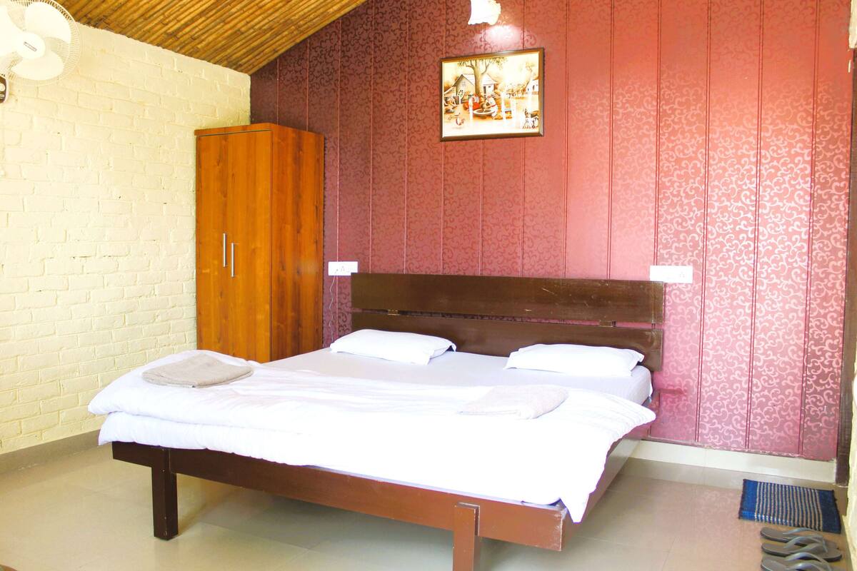 Un dormitorio con cama de madera, ropa de cama blanca, armario de madera y pared con diseño.