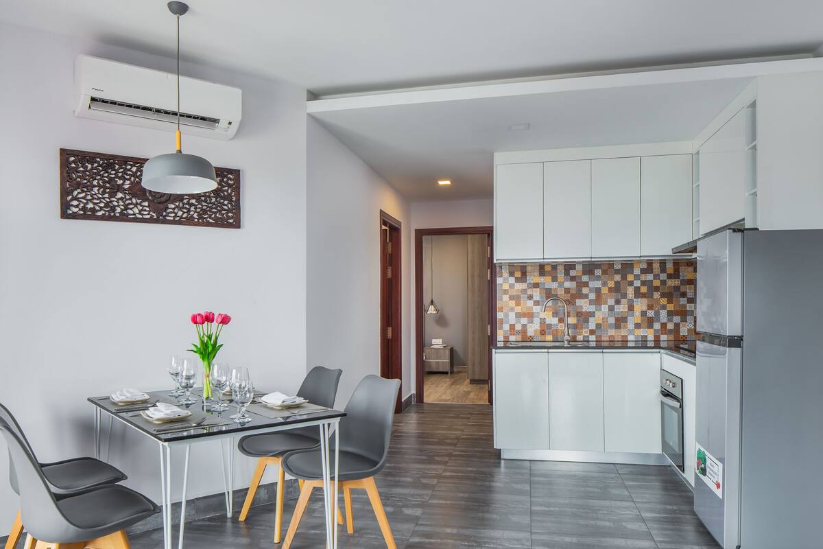 A modern kitchen with white cabinets, a tiled backsplash, and a built-in oven.