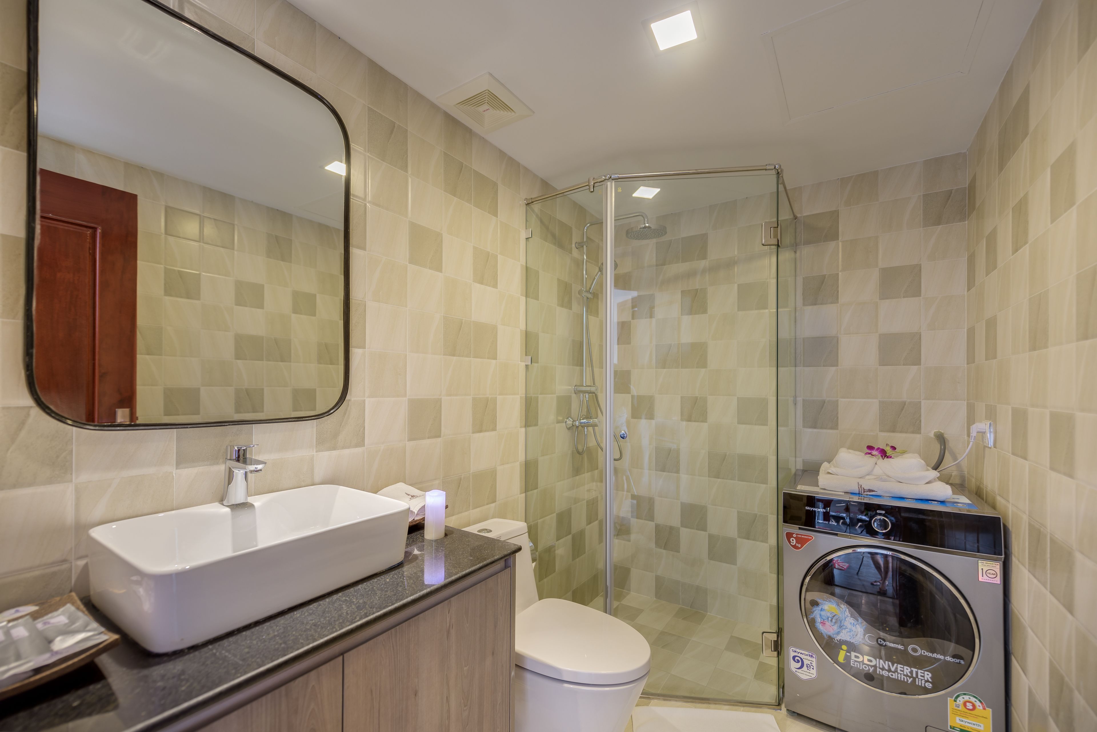A bathroom with a sink, toilet, and glass shower enclosure.