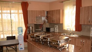 Una cocina moderna con electrodomésticos de acero inoxidable, dispensador de agua y espacio tipo bufé.