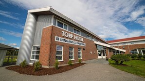 Un edificio de ladrillo con un letrero que dice "TORP HOTEL" y "INNGANG KAFETERIA".