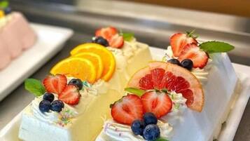 A dessert display with various fruit-topped cakes.