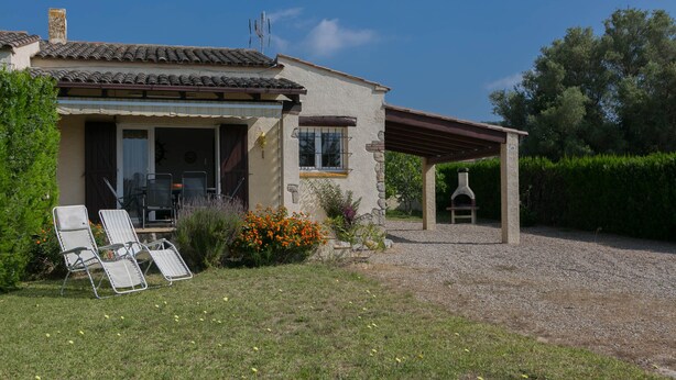 Une maison dotée d’un patio couvert, d’un espace salon extérieur et d’une cheminée.