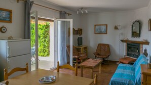 Un salon confortable avec une table à manger, des chaises, un canapé, une cheminée et un téléviseur.