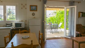 Une cuisine équipée d’une table à manger, de chaises, d’un four à micro-ondes et d’un réfrigérateur.