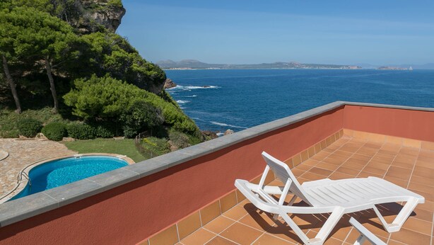 A terrace with a pool, a white lounge chair, and a view of the sea and mountains. - 3 bedroom apartment in Aiguafreda, Begur. Terrace, panoramic views, pool. (Ref:H23) (Begur)