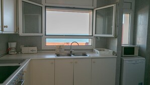 A kitchen with a window, a sink, a microwave, and a stove. - 3 bedroom apartment in Aiguafreda, Begur. Terrace, panoramic views, pool. (Ref:H23) (Begur)