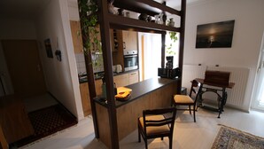 Eine moderne Küche mit einer Holztischinsel, einem Essbereich mit Tisch und Stühlen sowie einem großen Fenster für natürliches Licht.