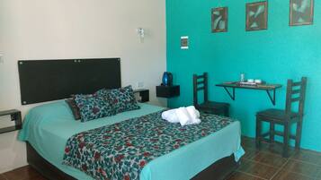 A room with a bed, a small table, and a chair.