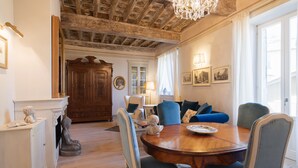 A dining area with a wooden table, blue upholstered chairs, and a chandelier. - Prestigious apartment with panoramic terrace, located in the center of Cortona. (Cortona)