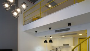 A modern interior with a living area, kitchen, and staircase. - Coordinat Suits (Izmir)