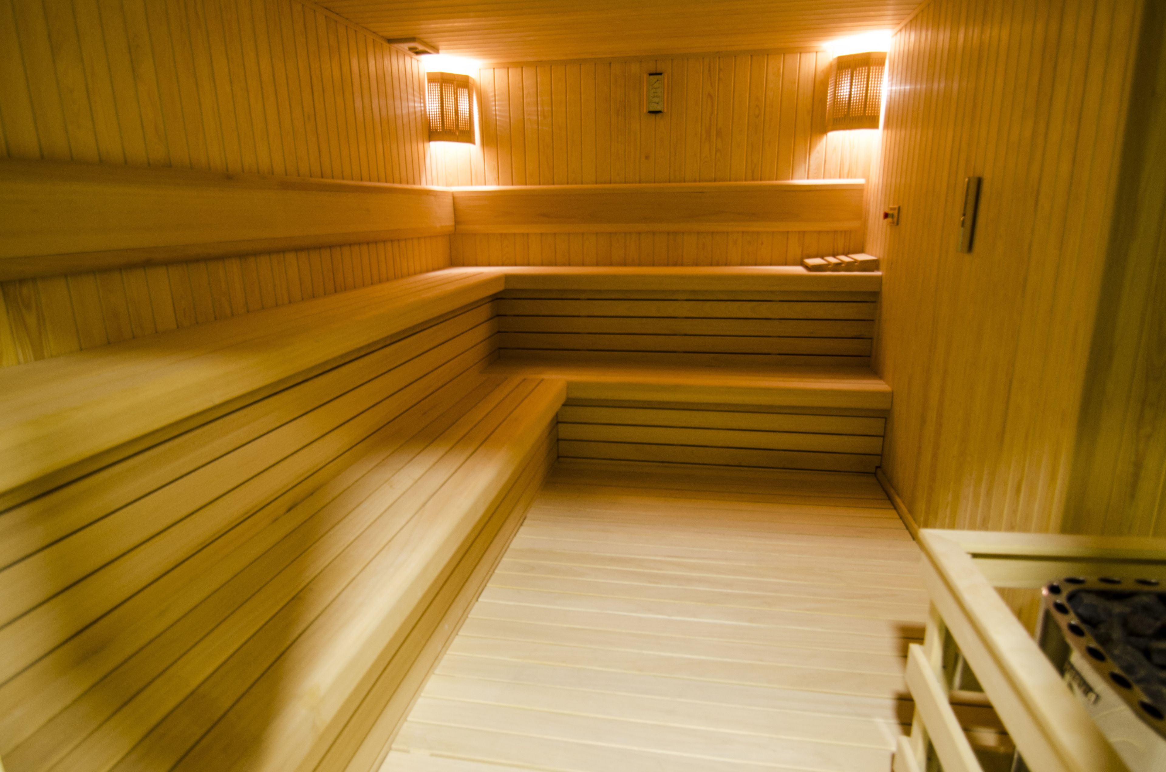 Una sauna con bancos de madera y un banco en la parte inferior.