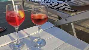 A poolside setting with two glasses of red beverages on a white table. - independent villa, air-conditioned, ideal for couples (peschici)