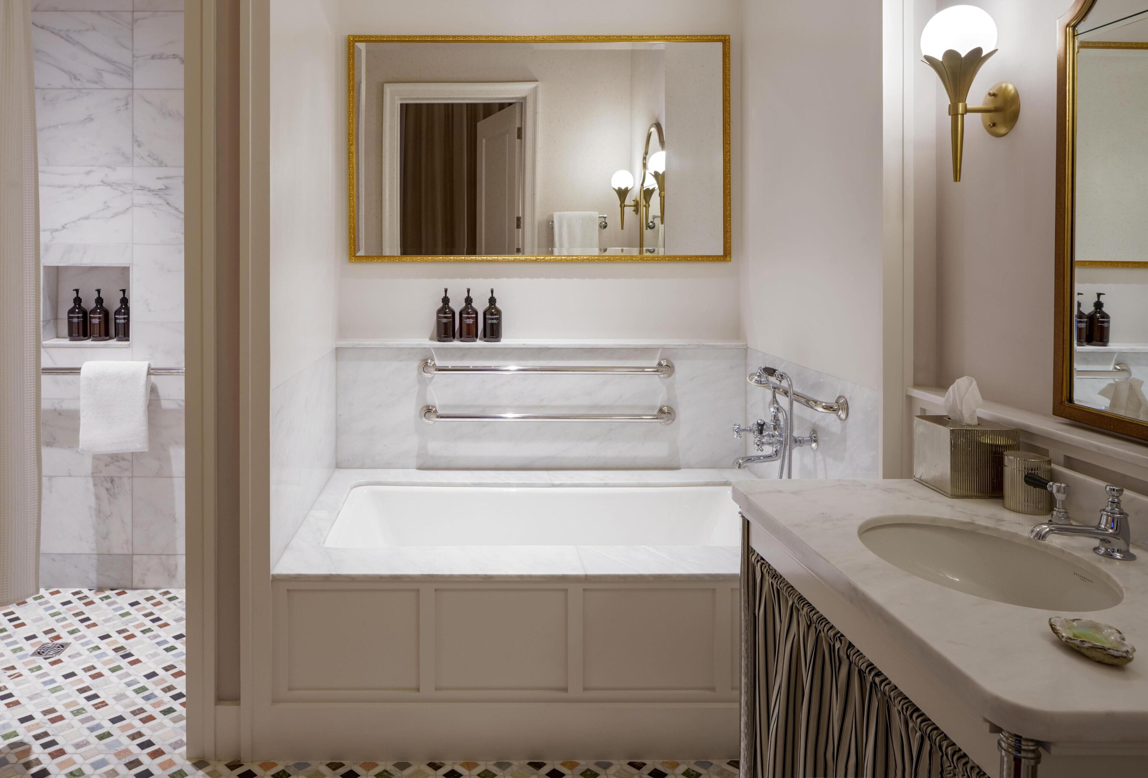 Une salle de bain avec une baignoire, un meuble-lavabo et un grand miroir.