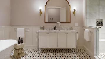 A bathroom with a white vanity, a large mirror, and a shower area.