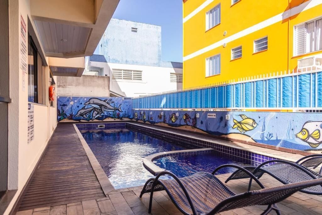 Una piscina al aire libre, sillones reclinables de piscina