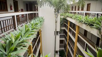 Un edificio de varios niveles con balcones, cada uno decorado con plantas en macetas.