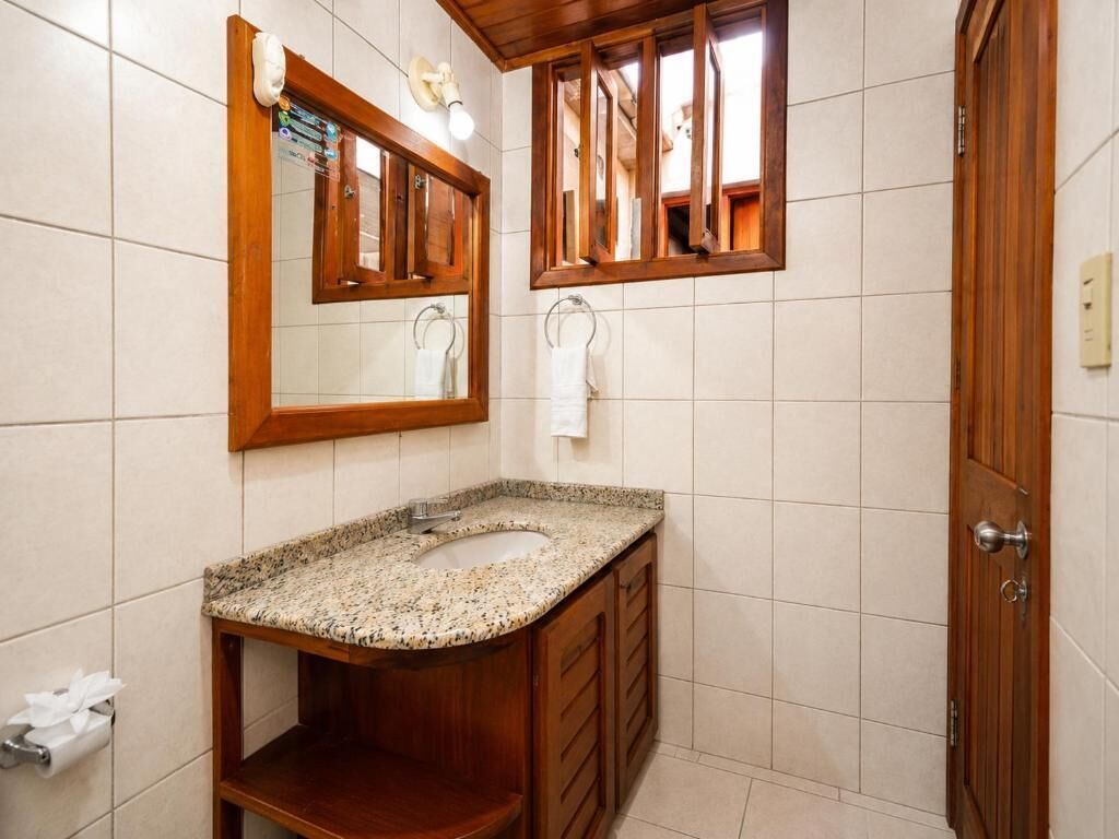 A bathroom with a wooden vanity, a sink, and a mirror.