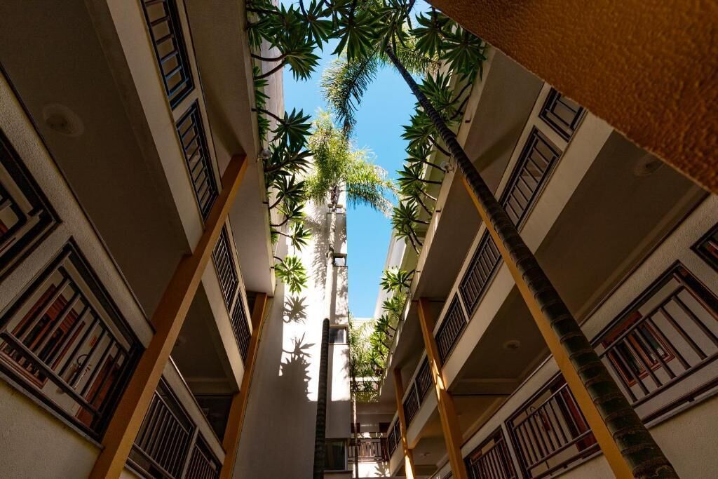 Un couloir doté de nombreux balcons, chacun étant pourvu d’une rambarde et offrant une vue sur le ciel.