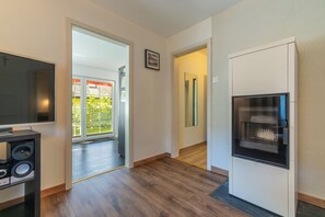 A modern kitchen with a built-in oven, a flat-screen TV, and a large window.