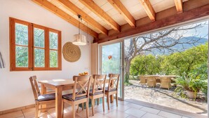 Un comedor con muebles de madera, un ventanal y vistas al exterior.