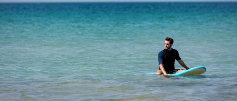 En person som sitter på en surfbräda i havet.