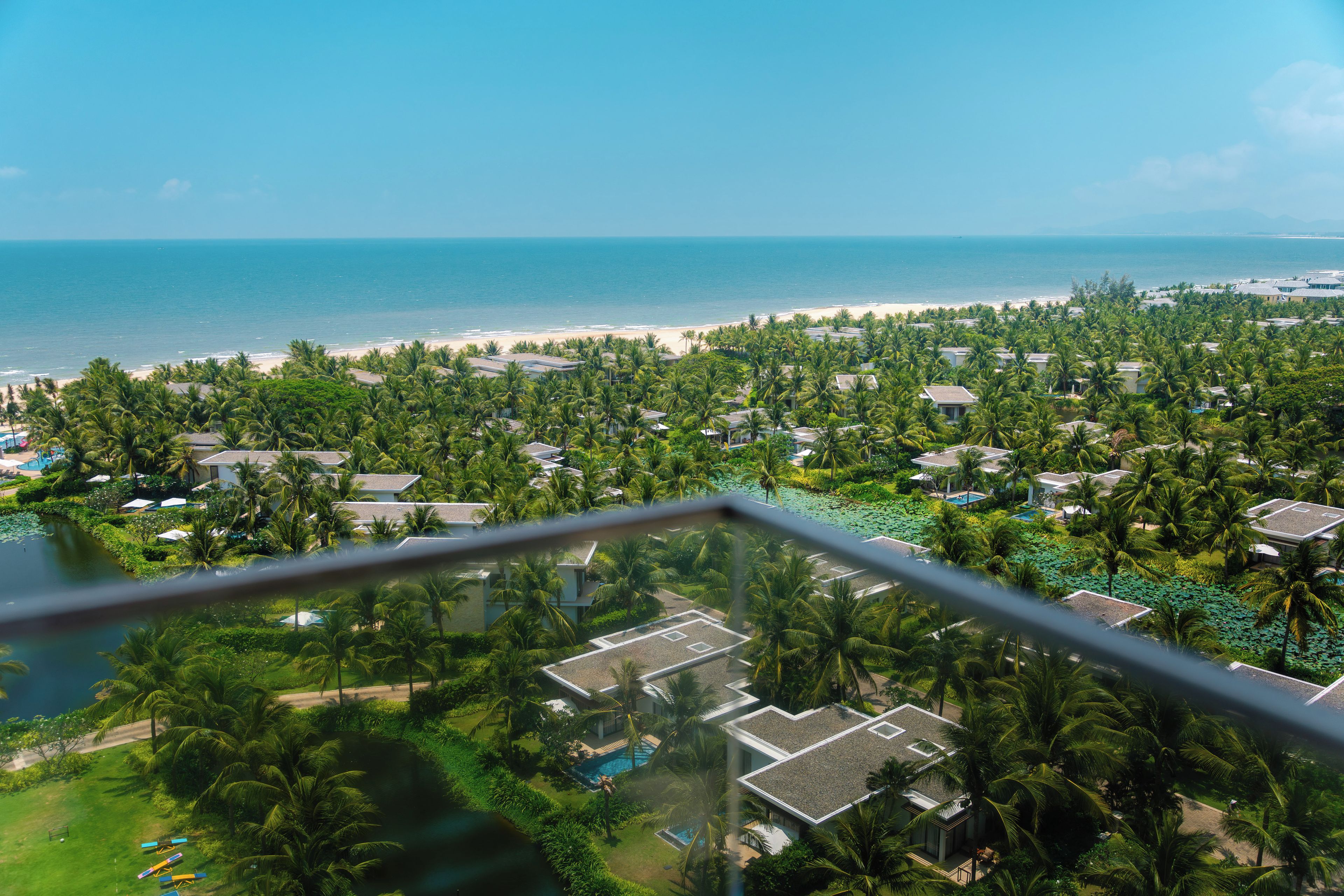 A resort with multiple buildings, a beach, and a view of the ocean.