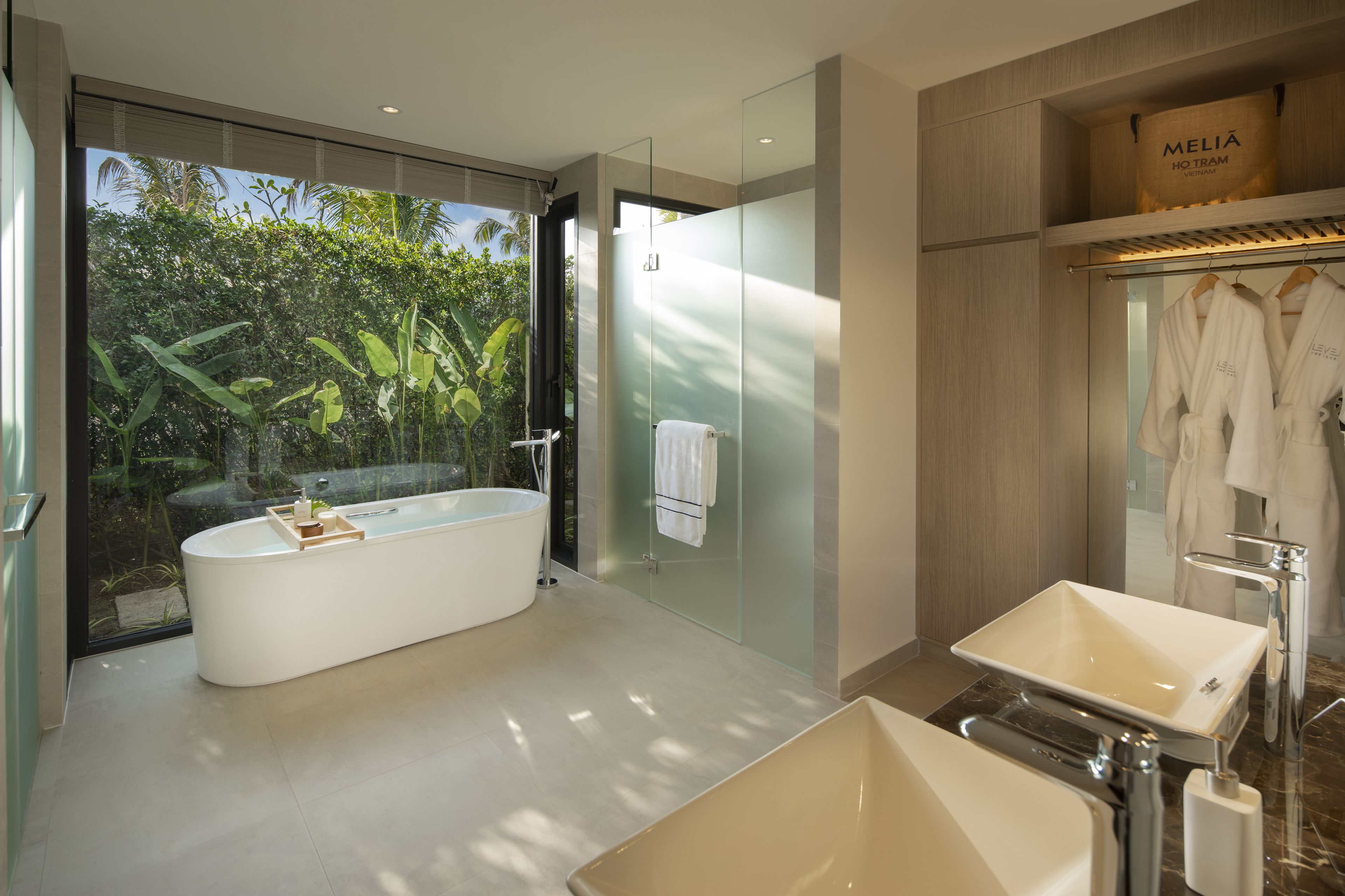Un baño moderno con una bañera independiente, un tocador con un lavabo grande y un box de ducha de vidrio.